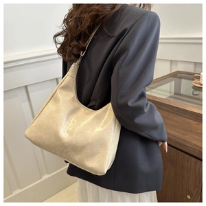 Detail of cream vintage tote bag showing premium leather texture and crescent shape design