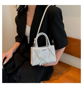 Détail du mini sac à main blanc en PU avec nœud perlé et logo métallique JINGPIN
