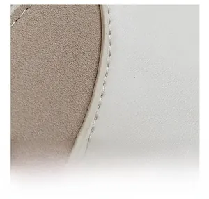 Detail of light brown suede and cream leather stitching on a stylish shoulder bag