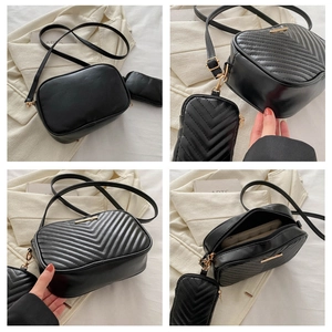 Detail view of black chevron quilted crossbody bag set with golden zippers and interior lining