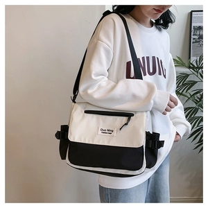 Detail of canvas messenger bag with contrast panels and adjustable side buckles