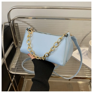 Detail of light blue baguette bag with thick gold chain and leather shoulder strap