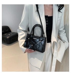 Détail du sac à main noir avec décoration en ruban de soie et perles blanches élégantes