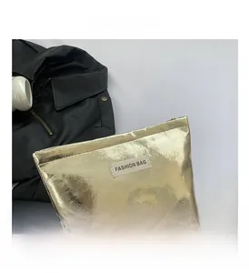 Close-up of golden faux leather makeup bag with fine scale texture and fashion label