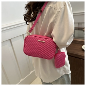Detail of rose pink V-quilted crossbody bag with matching hanging coin purse and gold hardware