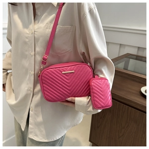 Detail view of pink quilted crossbody bag set with elegant V-stitching and gold hardware