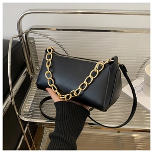 Close-up of black PU leather bag with decorative gold chain and slim shoulder strap