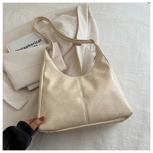 Chic cream white PU leather hobo bag with vintage textures shown on a white suit jacket