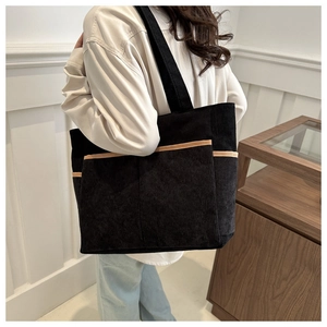 Detail view of large corduroy tote bag featuring multi-pocket design and contrast trim edges