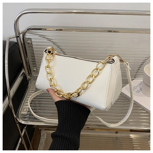 Detail view of white leather shoulder bag with decorative thick gold chain strap and zipper