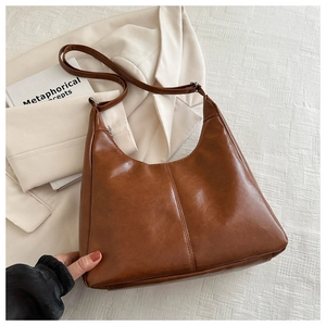 Detail view of the brown leather hobo bag with a zipper and fine shoulder strap for daily use