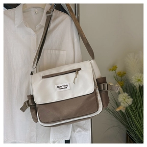 Close-up of color-block canvas messenger bag with adjustable strap and zip pocket