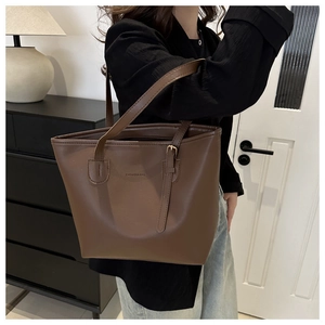 Detail of matte brown tote bag with FASHION & BAG embossing and adjustable strap