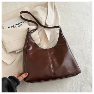 Detail of dark brown faux leather tote bag with vertical stitching and adjustable strap