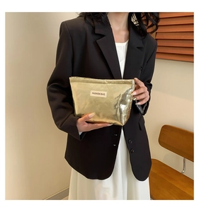 Detailed view of a metallic gold makeup bag with a minimalist FASHION BAG label