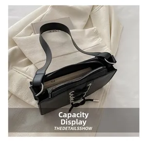 Détail de l'intérieur du sac sous le bras en cuir noir montrant sa grande capacité