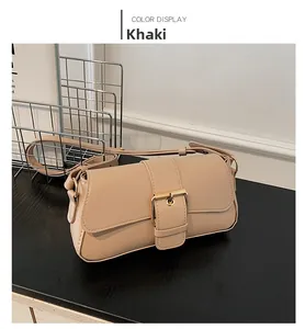 Detail view of the khaki leather shoulder bag with a large golden metal buckle decoration