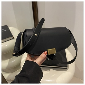 Detailed view of black semi-circular saddle bag with golden rectangular metal lock