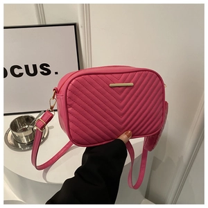 Detail of rose pink quilted crossbody bag with gold bar accent and mini coin pouch