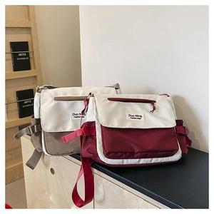 Detail of minimalist canvas messenger bags in red-white and brown-white color block design