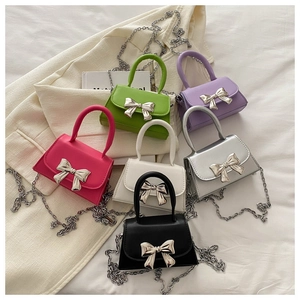 Detailed macro shot of various colorful mini bags featuring silver metal bow buckles