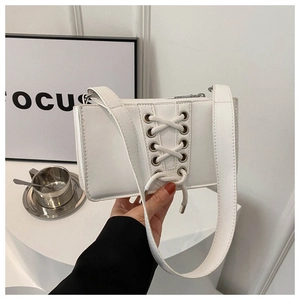 Détail du sac en similicuir blanc avec design à lacets style corset et œillets en métal