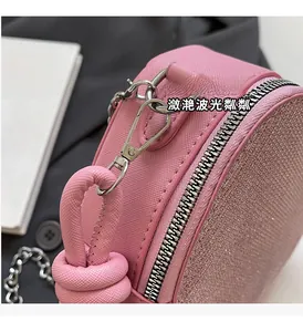 Close-up of pink sequin handbag with Saffiano leather texture and silver zipper detail