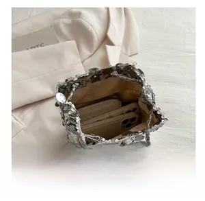 Silver sequin bucket bag capacity display showing a wallet and smartphone inside