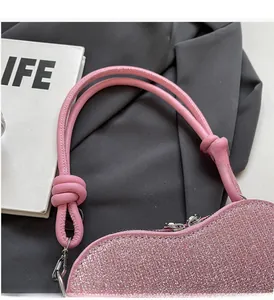 Close-up of pink sequin heart-shaped handbag with knotted handle and silver hardware