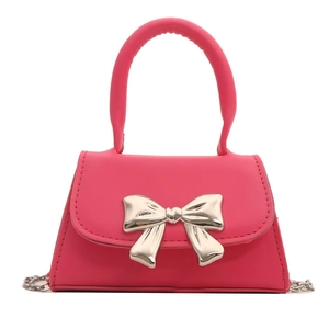 Mini rose pink crossbody bag with large gold metal bow accent and chain strap
