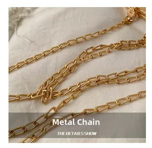 Detailed macro shot of the premium golden metal chain strap on a shimmering evening bag