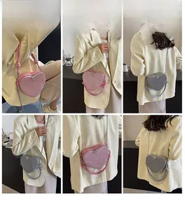 Detailed views of sequined heart-shaped crossbody bag with chain strap and handle
