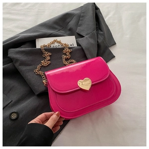 Detailansicht der fuchsiafarbenen Lackledertasche mit goldenem herzförmigem Metallschloss
