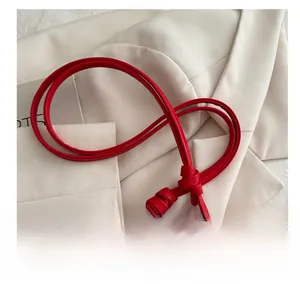 Detail of red heart-shaped shoulder bag with elegant knotted leather strap and neat stitching