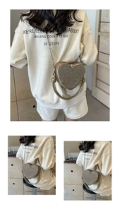 Macro shot of the heart-shaped bag's champagne gold sequins and silver metal chain strap