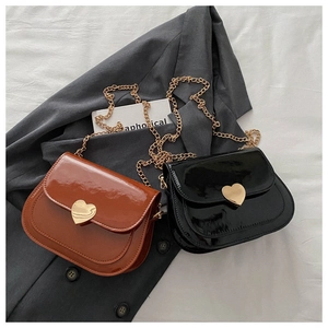 Nahaufnahme der Lackleder-Satteltasche mit herzförmiger Metallschnalle und goldener Kette