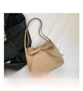 Détail du sac cabas beige montrant le grand nœud décoratif et le similicuir de qualité
