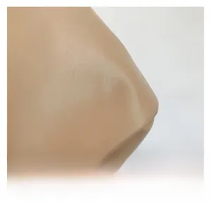 Gros plan du cuir beige à texture de litchi avec détails de couture sur le sac à main
