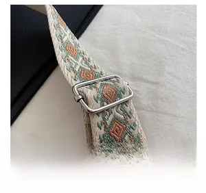 Close-up of adjustable woven strap featuring retro green and orange geometric embroidery