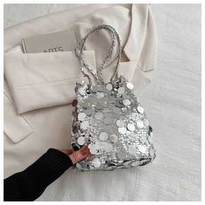 Detailed view of silver sequin bucket bag with elegant metallic chain strap decoration