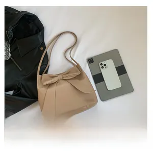 Vue détaillée du sac cabas beige à nœud avec accessoires et style à plat chic