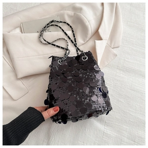 Detailed macro of shiny black sequin bucket bag with elegant metal chain strap texture
