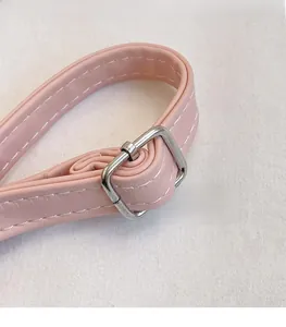 Detailed close-up of pink leather strap with silver buckle and white contrast stitching