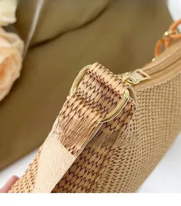 Detail of woven crescent bag with golden metal ring and smooth zipper closure