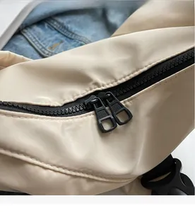 Detail of smooth double zippers and durable plastic buckle on the beige nylon tote bag