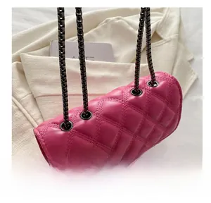 Detalle del bolso acolchado fucsia con cadena de metal a través de ojales metálicos