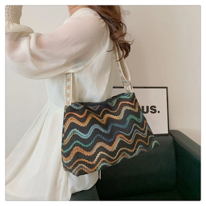 Detailed view of vintage patterned tote bag with embroidered strap worn by a model