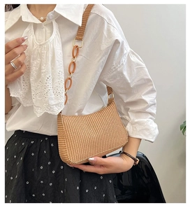 Detail of light brown woven shoulder bag featuring a stylish orange plastic chain strap