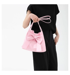 Détail du grand nœud rose sur un sac à main trapèze élégant pour femme en gros plan