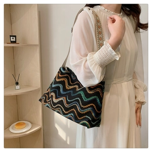 Detailed shot of an embroidered tote bag featuring colorful zigzag patterns and wide strap